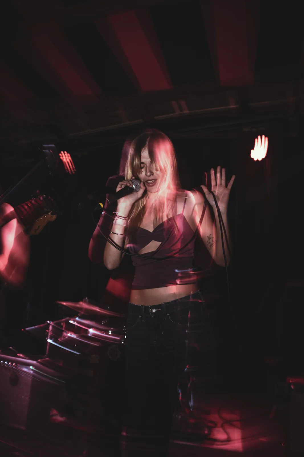 Elena singing under red stage lights at Will’s Pub